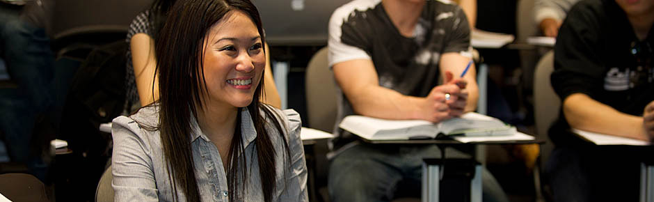 Monash University students smiling in lecture theatre